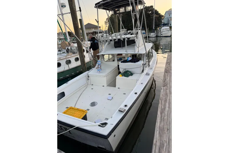 Slide: The Image of 1978 Bertram 31 Sportfisher Yanmars docked, featuring spacious deck and fishing equipment. - 18