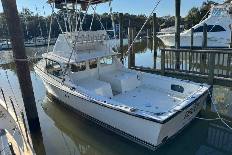 Slide: The Image of 1978 Bertram 31 Sportfisher Yanmars docked in a serene marina setting. - 28