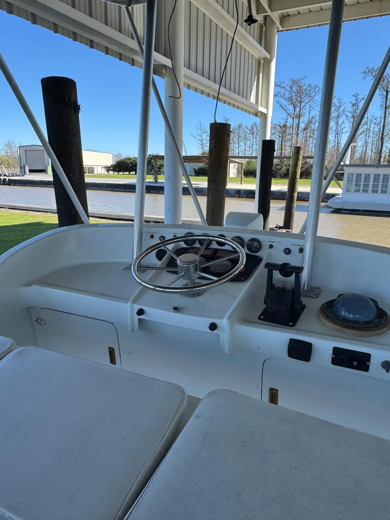 Slide: The Image of 1978 Bertram 31 Sportfisher Yanmars boat helm with steering wheel and controls. - 3