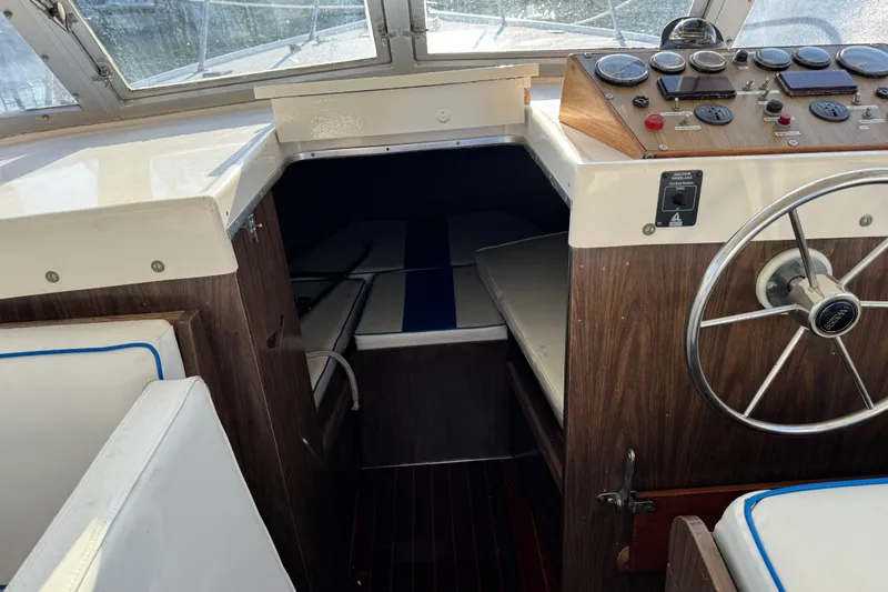 Slide: The Image of 1978 Bertram 31 Sportfisher Yanmars boat interior with steering wheel and cabin view. - 33