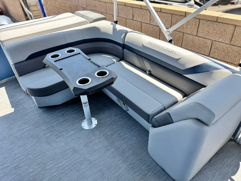 Slide: The Image of 2023 Bennington SX 21 pontoon boat interior with gray seating and cupholder table. - 15