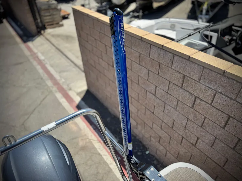 Slide: The Image of 2023 Bennington SX 21 boat with blue Power-Pole anchor, docked near a brick wall. - 19