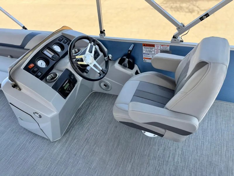 Slide: The Image of 2023 Bennington SX 21 boat helm with steering wheel and captain's chair. - 21