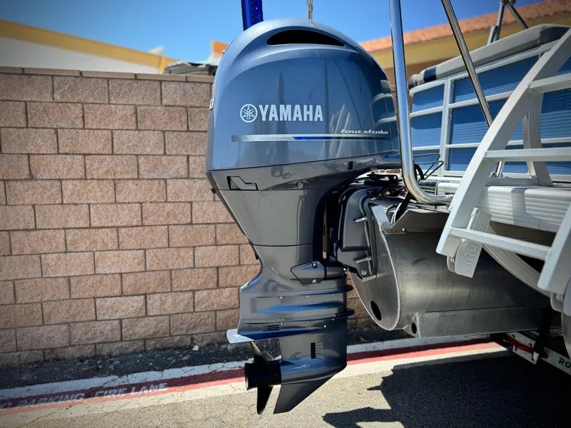Slide: The Image of 2023 Bennington SX 21 with Yamaha outboard motor, parked near a brick wall. - 6