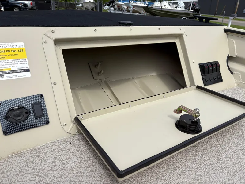 Slide: The Image of 2025 SeaArk 1652 Crappie boat storage compartment with open hatch and control panel. - 5