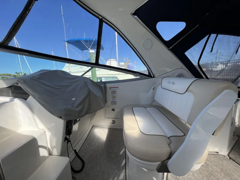 Slide: The Image of Interior of 2012 Sea Ray 310 Sundancer boat with beige seating and large windows. - 12