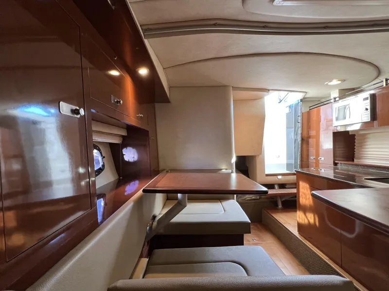 Slide: The Image of Interior of 2012 Sea Ray 310 Sundancer with wooden table and beige seating. - 20