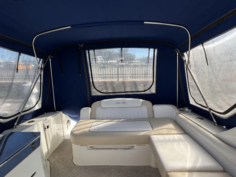 Slide: The Image of 2012 Sea Ray 310 Sundancer boat docked in marina, blue and white exterior. - 4