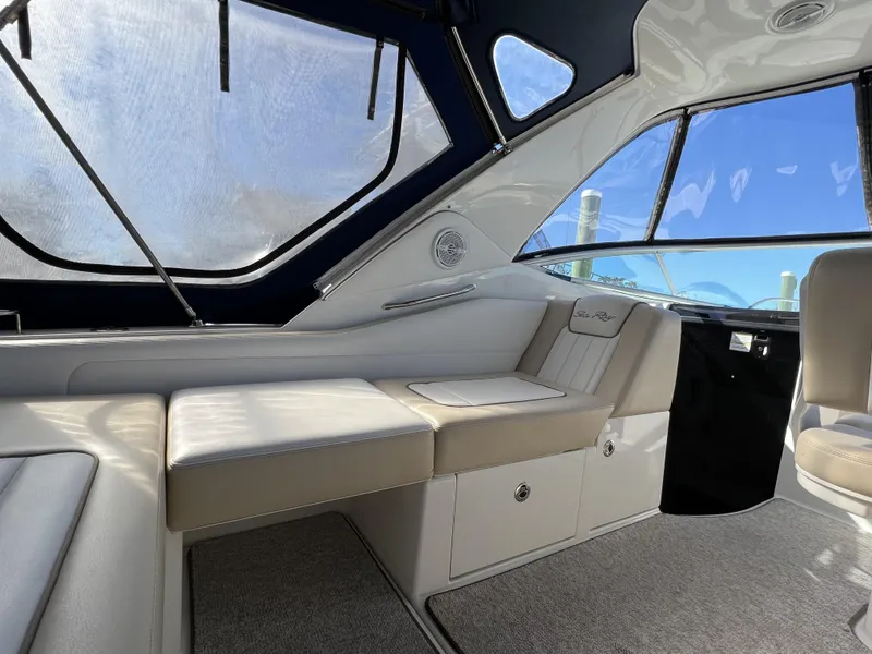 Slide: The Image of Interior of 2012 Sea Ray 310 Sundancer with white seating and blue canopy. - 7