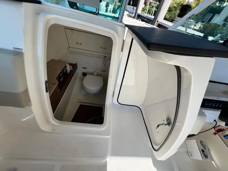 Slide: The Image of 2023 Boston Whaler 280 Vantage boat interior with open restroom compartment. - 15