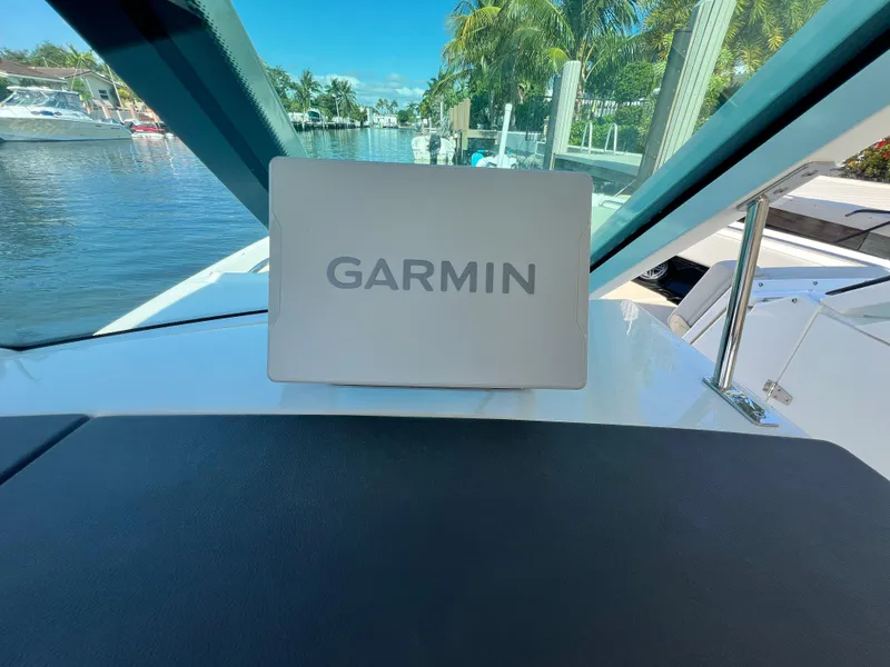 Slide: The Image of 2023 Boston Whaler 280 Vantage with Garmin navigation system, docked by a scenic waterfront. - 16
