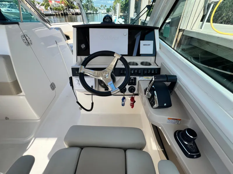 Slide: The Image of 2023 Boston Whaler 280 Vantage helm with modern controls and steering wheel. - 18