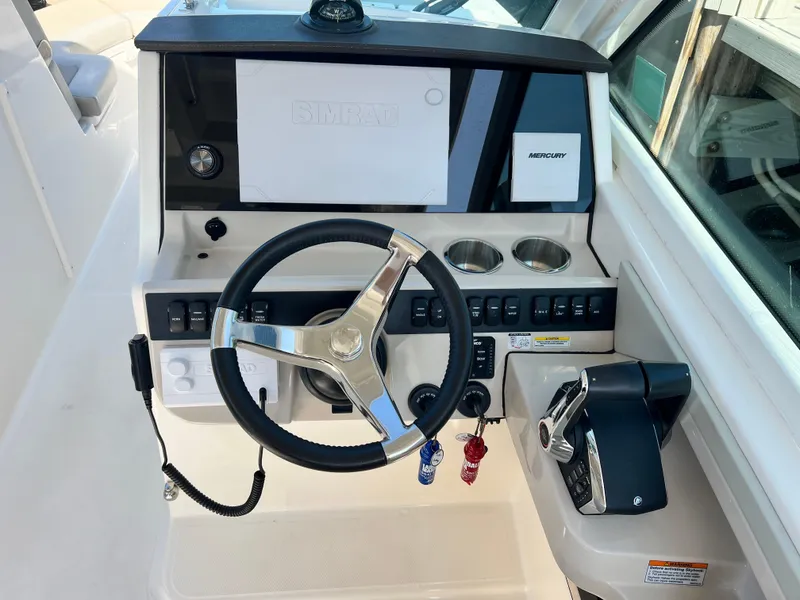 Slide: The Image of 2023 Boston Whaler 280 Vantage helm with steering wheel and control panel. - 19