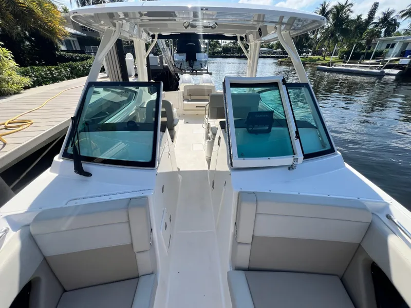 Slide: The Image of 2023 Boston Whaler 280 Vantage boat docked by a scenic waterfront. - 22