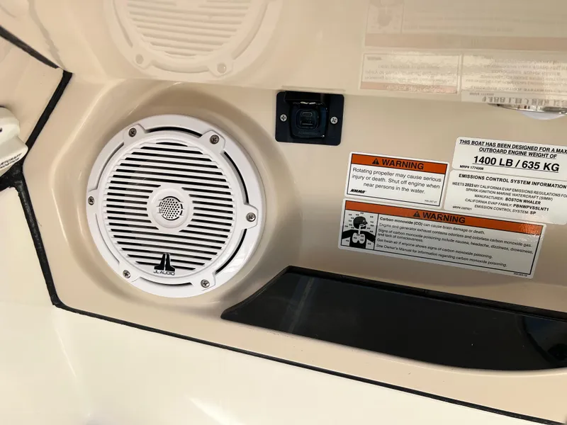 Slide: The Image of 2023 Boston Whaler 280 Vantage speaker and warning labels on boat interior. - 24