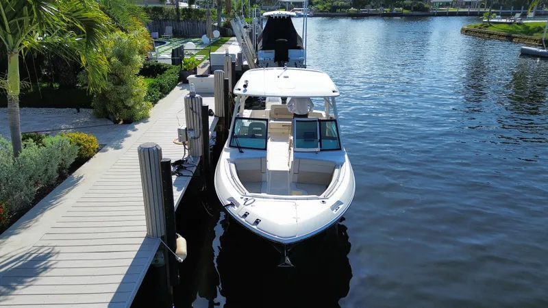 Slide: The Image of 2023 Boston Whaler 280 Vantage docked by a scenic waterfront. - 4