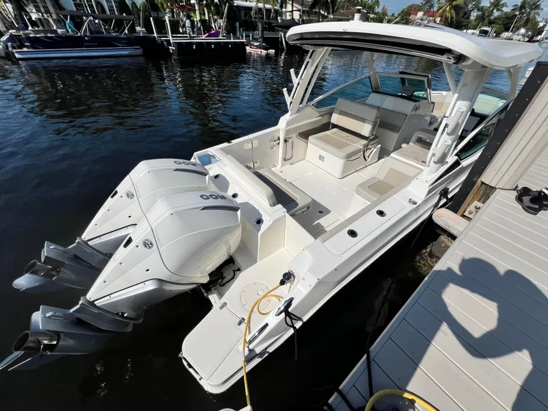 Slide: The Image of 2023 Boston Whaler 280 Vantage boat docked, featuring dual outboard engines and spacious seating. - 7