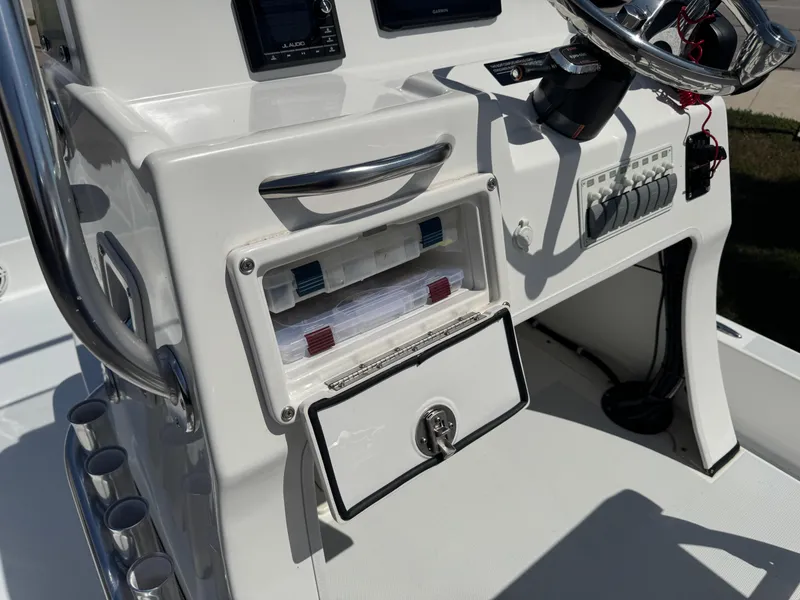Slide: The Image of 2019 Shallow Sport 21 Sport boat console with storage compartment and steering wheel. - 10