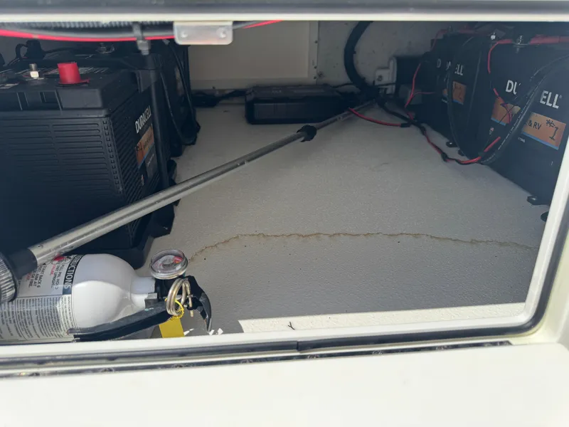 Slide: The Image of Storage compartment of 2019 Shallow Sport 21 Sport boat with batteries and fire extinguisher. - 13