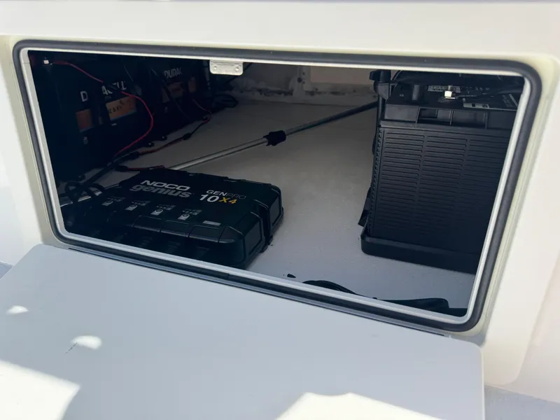 Slide: The Image of 2019 Shallow Sport 21 Sport boat battery compartment with NOCO Genius charger. - 14