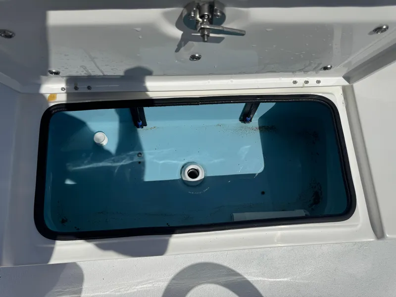 Slide: The Image of Livewell compartment on a 2019 Shallow Sport 21 Sport boat, open lid, blue interior. - 18