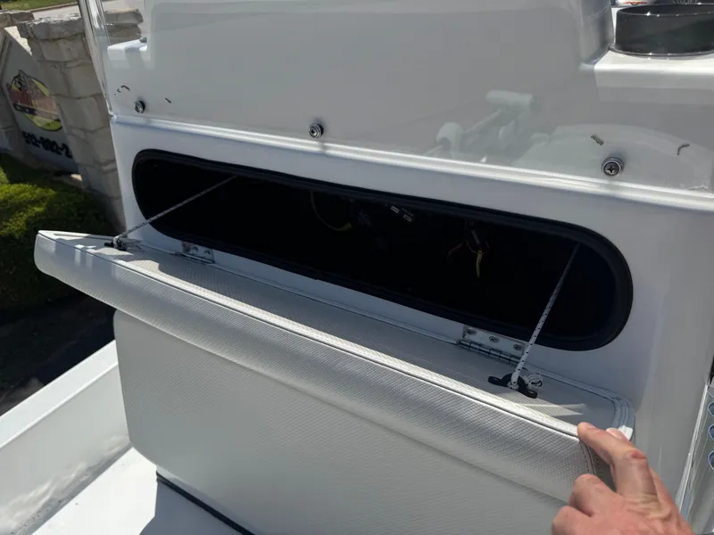 Slide: The Image of 2019 Shallow Sport 21 Sport boat storage compartment with open lid and visible interior. - 21