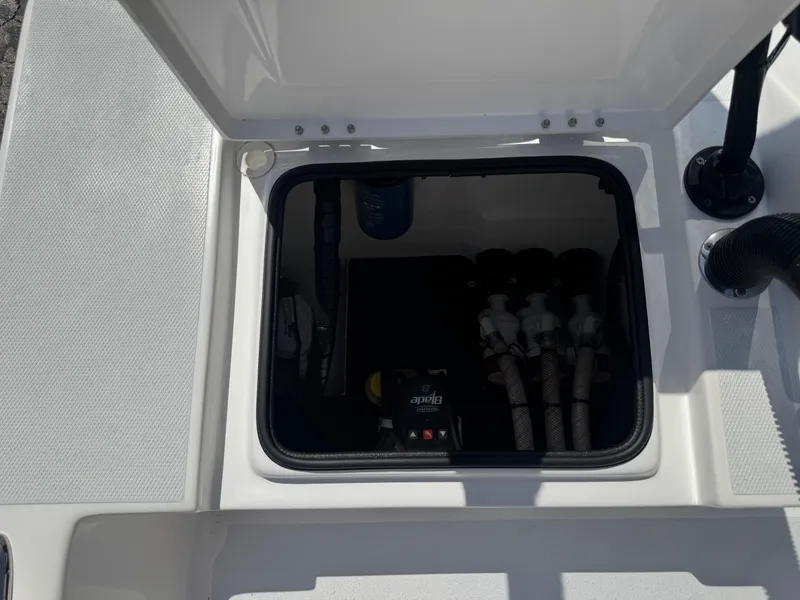 Slide: The Image of 2019 Shallow Sport 21 Sport boat storage compartment with visible plumbing and equipment. - 28