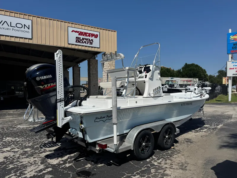 Slide: The Image of 2019 Shallow Sport 21 Sport boat on trailer, parked outside dealership, featuring Yamaha outboard motor. - 3