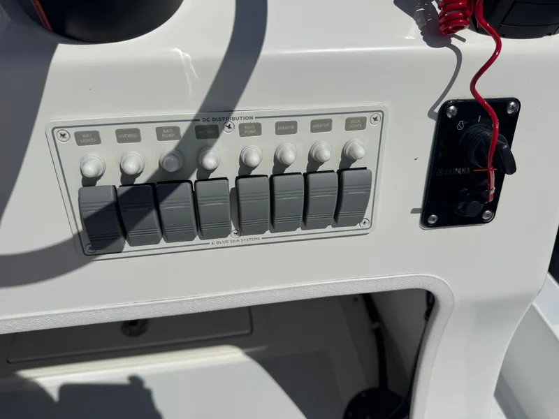 Slide: The Image of Control panel of a 2019 Shallow Sport 21 Sport boat with switches and safety lanyard. - 9