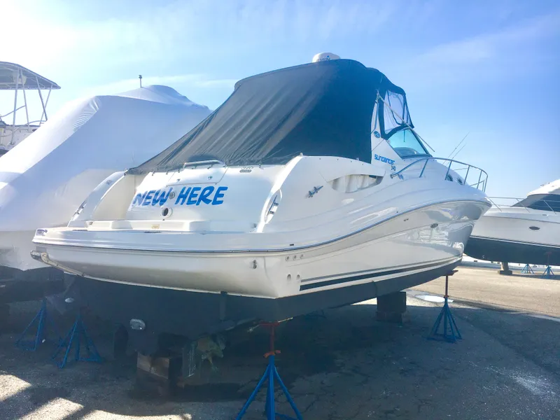 The Image of 2004 Sea Ray 340 Sundancer boat on stands, covered, in a marina setting. - 0