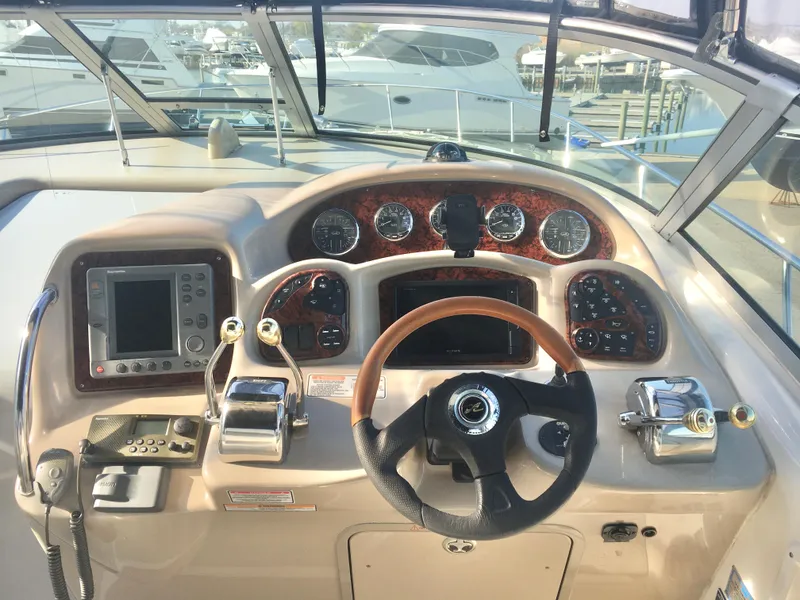 Slide: The Image of 2004 Sea Ray 340 Sundancer helm with gauges, steering wheel, and navigation equipment. - 10
