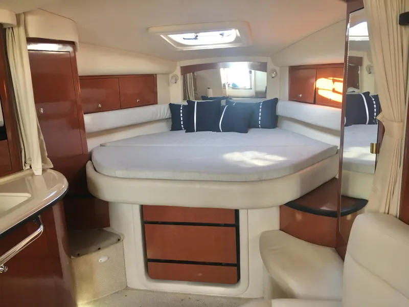 Slide: The Image of 2004 Sea Ray 340 Sundancer cabin interior with bed, wooden cabinets, and skylight. - 16