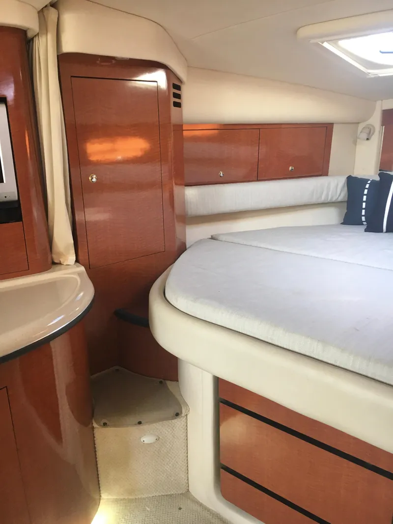 Slide: The Image of 2004 Sea Ray 340 Sundancer cabin interior with wood cabinetry and bed. - 21