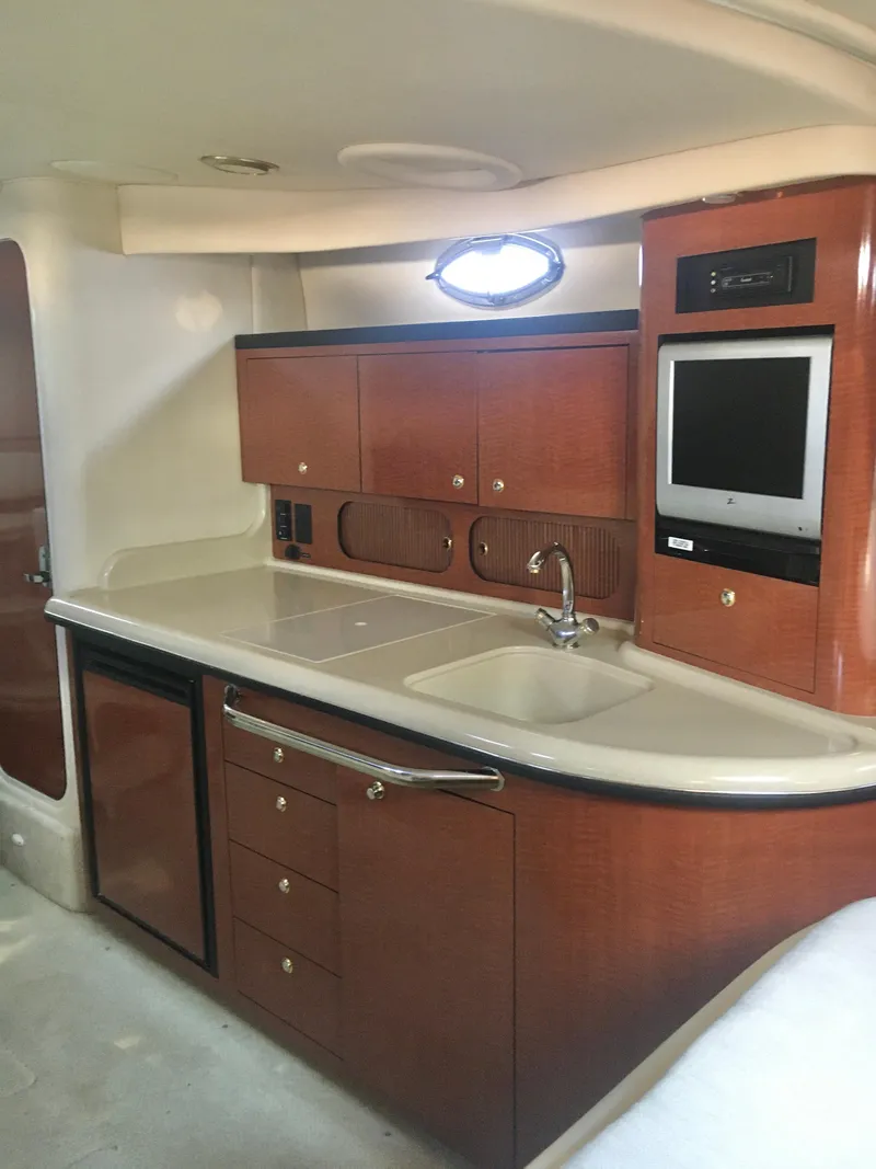 Slide: The Image of 2004 Sea Ray 340 Sundancer interior with kitchenette, sink, and built-in TV. - 22