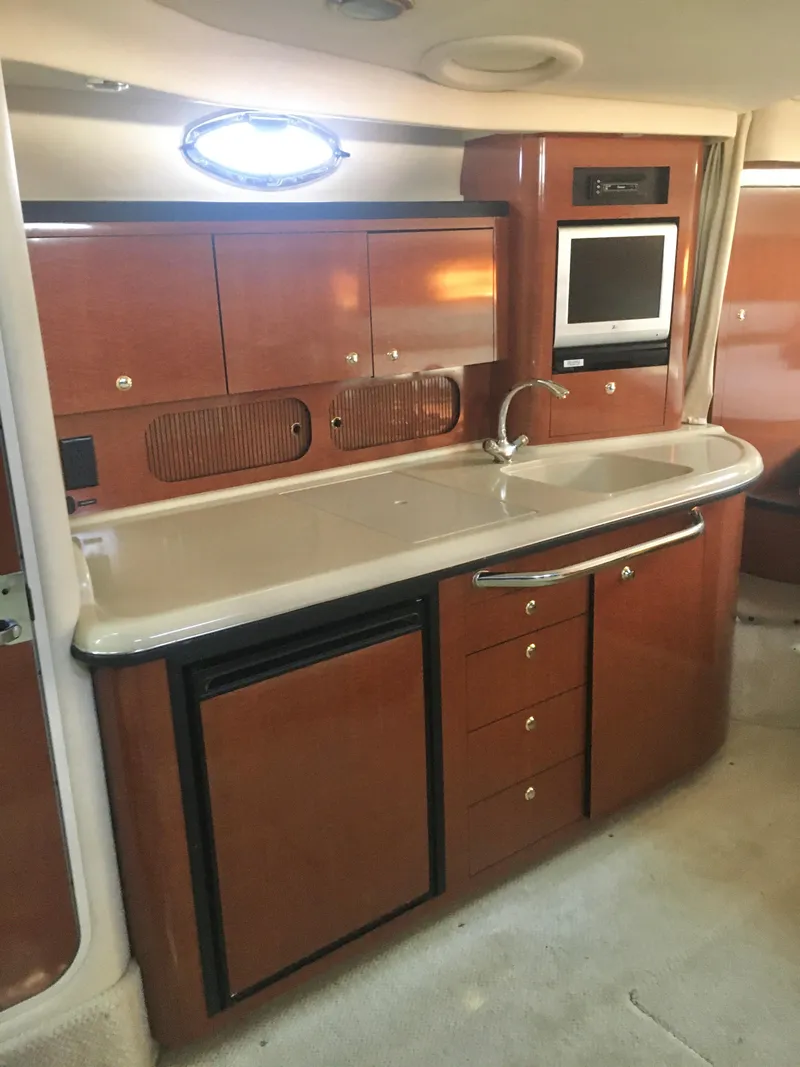 Slide: The Image of 2004 Sea Ray 340 Sundancer interior kitchen with wood cabinetry and modern appliances. - 23
