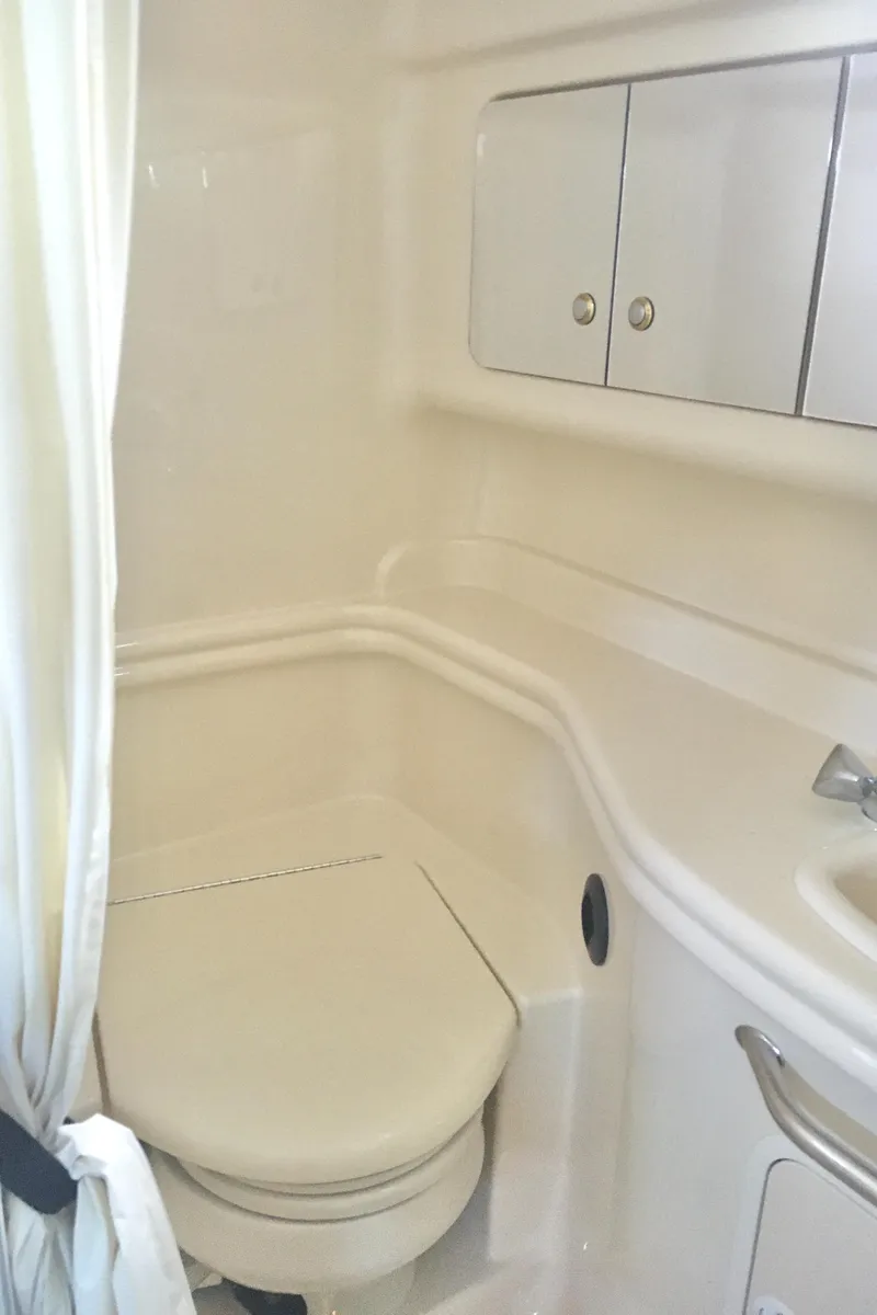 Slide: The Image of 2004 Sea Ray 340 Sundancer bathroom with white fixtures and storage cabinets. - 24