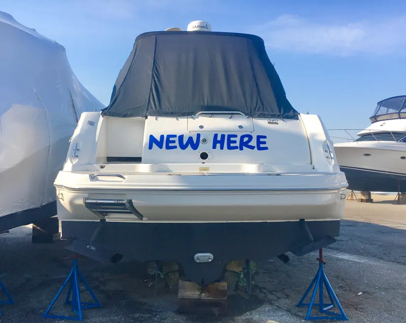 Slide: The Image of 2004 Sea Ray 340 Sundancer boat with "NEW HERE" text, covered and docked. - 3