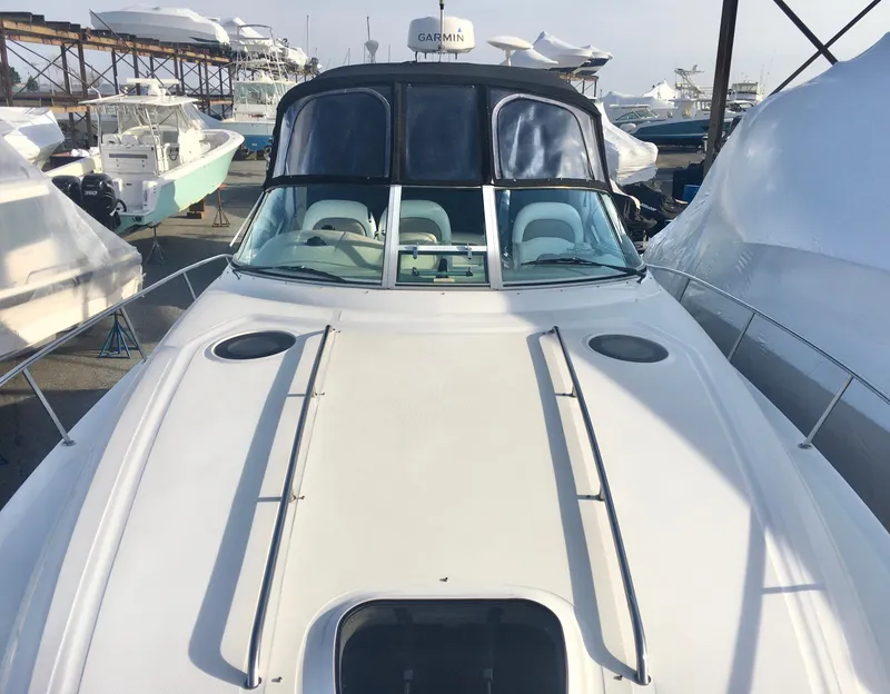 Slide: The Image of 2004 Sea Ray 340 Sundancer boat docked, showcasing sleek design and spacious deck. - 5