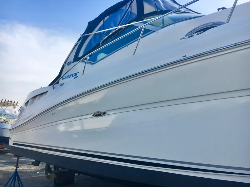 Slide: The Image of 2004 Sea Ray 340 Sundancer boat with sleek white hull and blue canopy. - 8