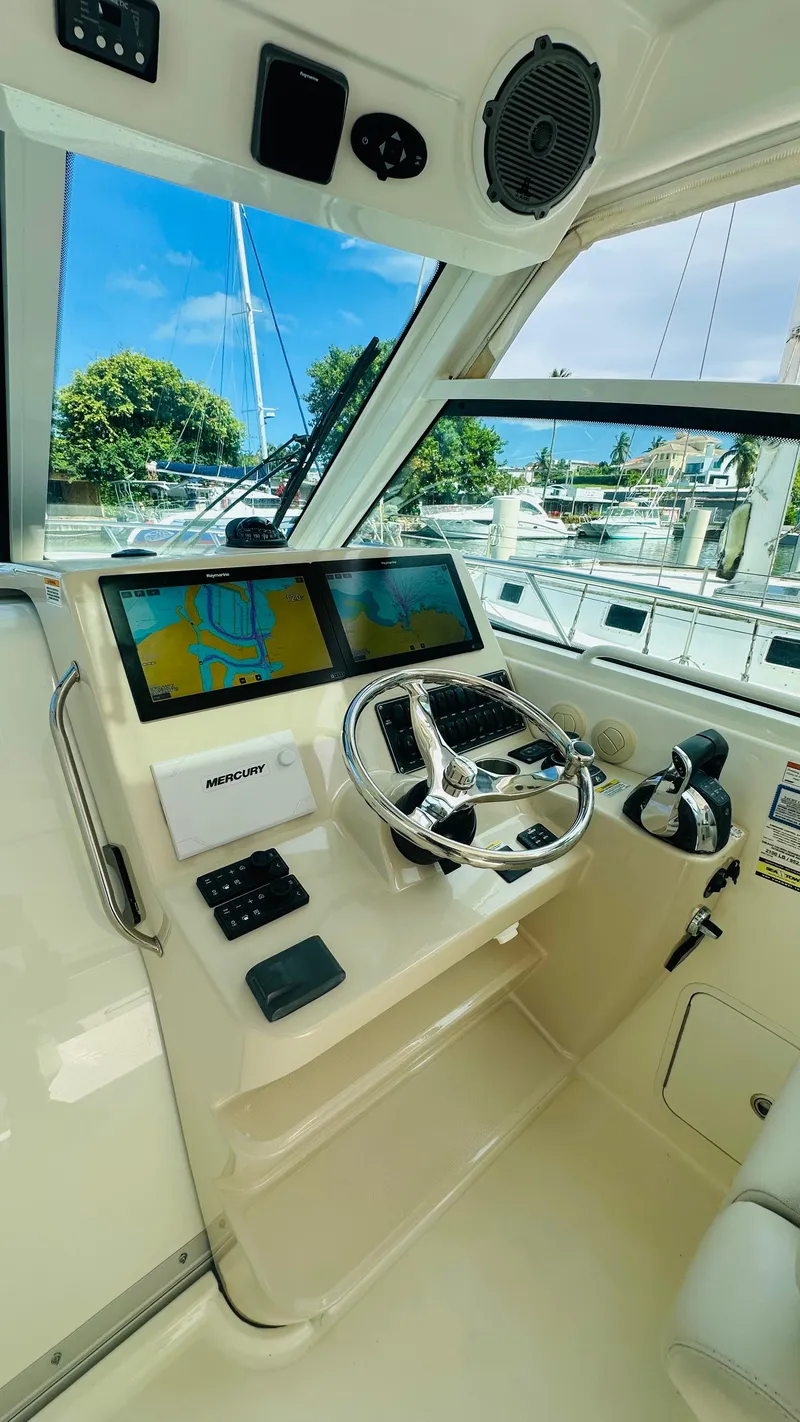 Slide: The Image of 2018 Boston Whaler 345 Conquest helm with dual screens and steering wheel. - 10