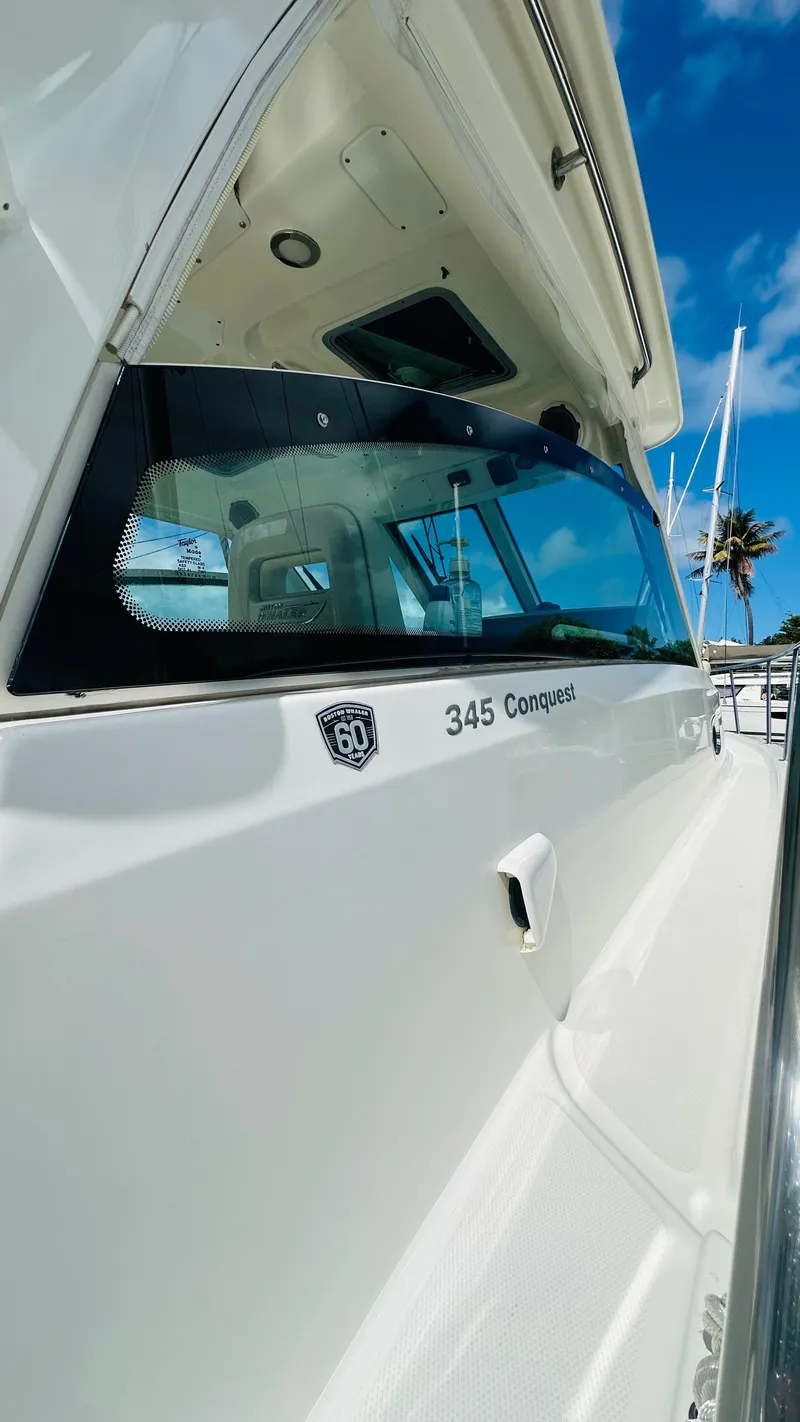 Slide: The Image of 2018 Boston Whaler 345 Conquest boat, sleek design, docked under clear blue sky. - 12