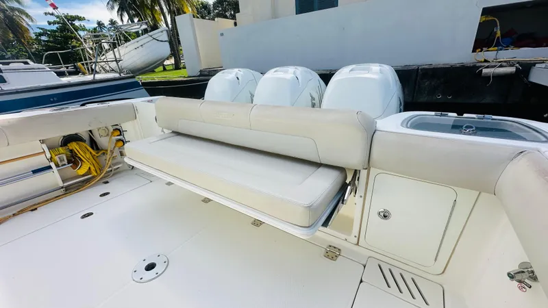 Slide: The Image of 2018 Boston Whaler 345 Conquest boat with cushioned seating and triple outboard engines. - 3