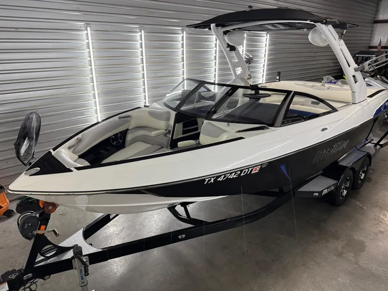 Slide: The Image of 2017 Malibu Wakesetter 23 LSV boat in a garage, sleek design, black and white exterior. - 4