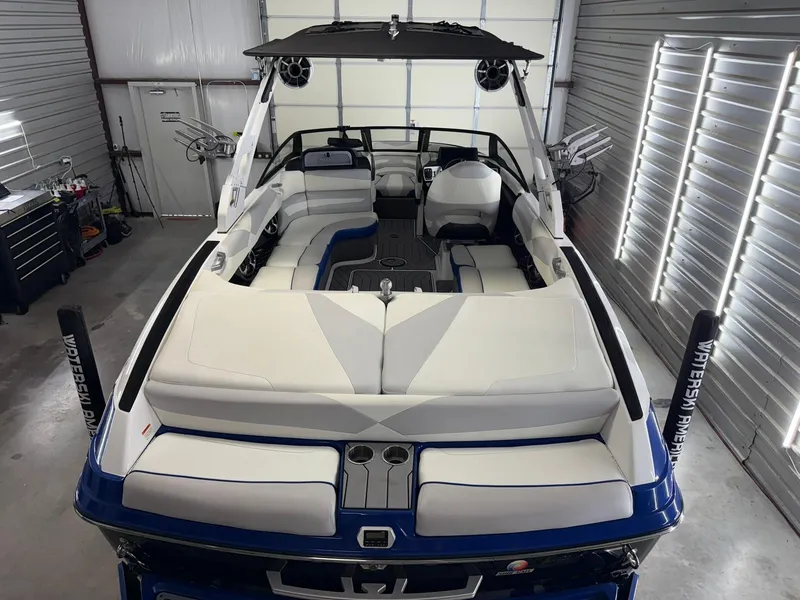 Slide: The Image of 2017 Malibu Wakesetter 23 LSV boat in a garage, featuring white and blue seating. - 6