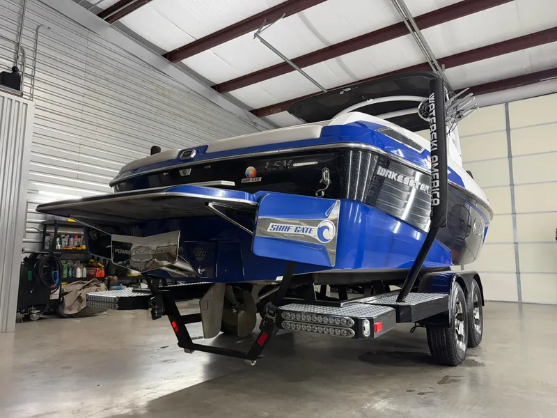 Slide: The Image of 2017 Malibu Wakesetter 23 LSV boat in a garage, blue and black design. - 7