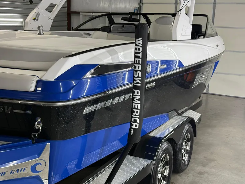 Slide: The Image of 2017 Malibu Wakesetter 23 LSV boat in garage, blue and black design, on trailer. - 8