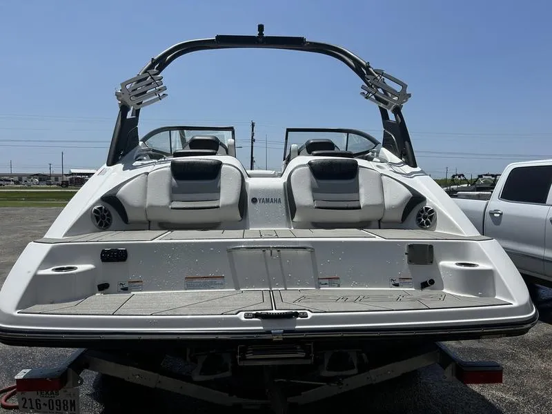 Slide: The Image of 2022 Yamaha Boats 212XE, rear view, showcasing sleek design and spacious seating. - 2