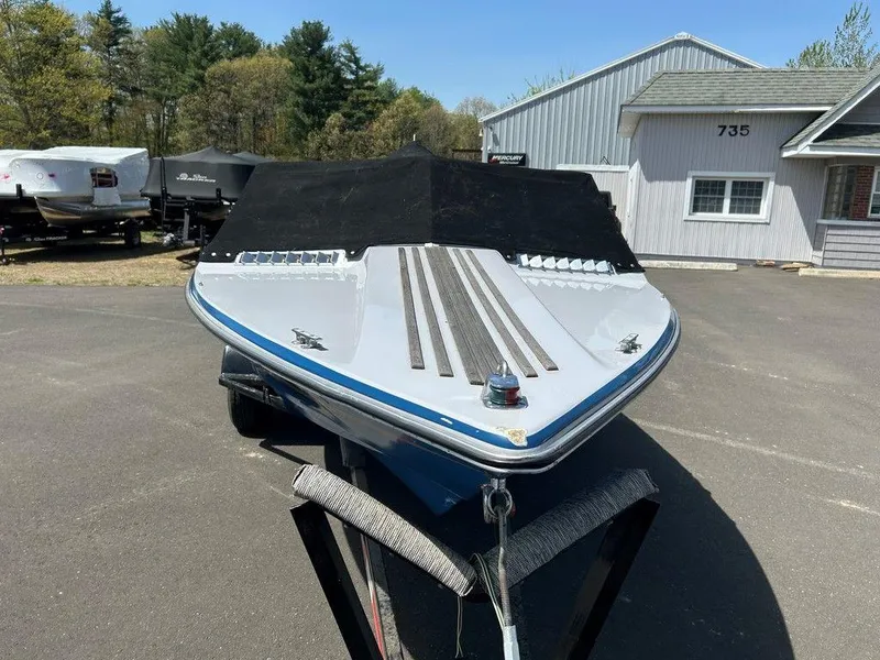 Slide: The Image of 1980 Ski Supreme boat with cover, parked outdoors near a building. - 10