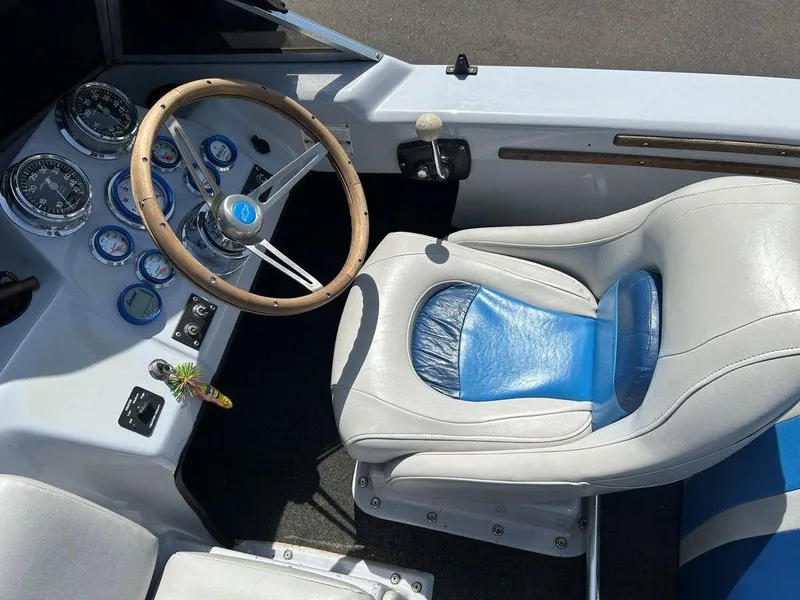 Slide: The Image of 1980 Ski Supreme boat interior with steering wheel, gauges, and white-blue seat. - 14