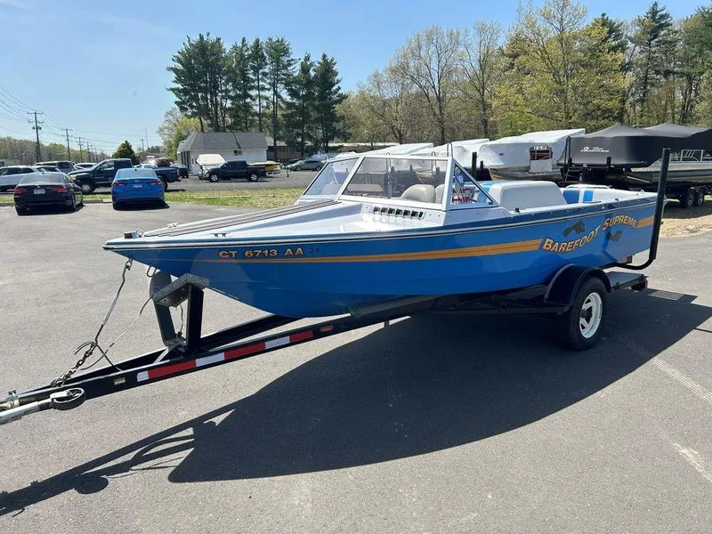 Slide: The Image of 1980 Ski Supreme boat on trailer in parking lot, blue with yellow accents. - 3